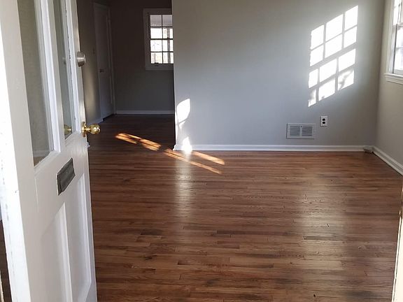 Living room into dining room with refinished hard wood door thru front door.