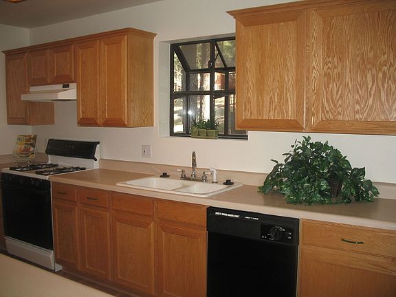 Cook's kitchen with lots of counter space, oak cabinetry and bay window.