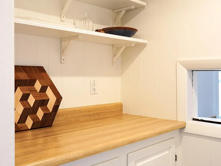 Pantry area with two work surfaces opposite of each other and storage below and above on each side.