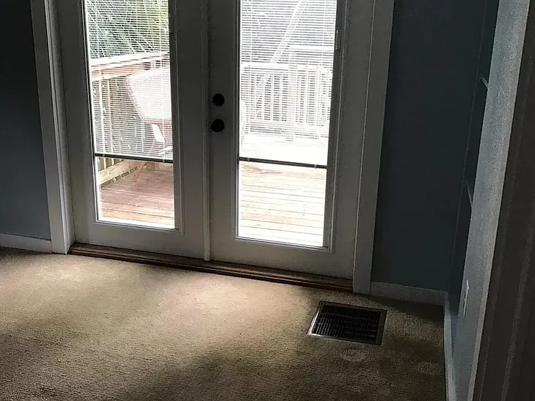 Master bedroom with en suite bathroom and french doors leading out to a deck