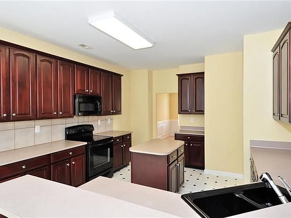 Large, open kitchen with 42 inch cherry cabinets, wrap-around breakfast bar