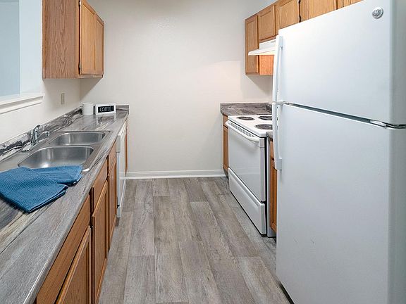 Galley style kitchens featuring wood-style flooring, updated countertops, and ample cabinetry.