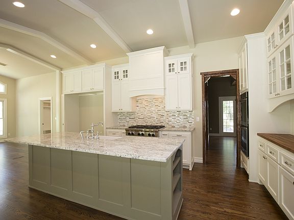  Generous granite island seats four, is accented by an extra-deep farmhouse sink with chrome fixture, stainless steel tub dishwasher and full-extension cabinet drawers with soft-close feature.