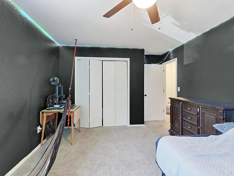Spacious secondary bedroom with large windows, soft natural light, and plenty of room for guests, kids, or a home office.