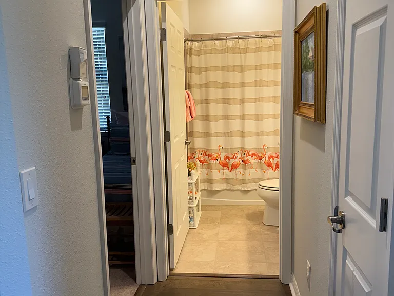 Hallway to guest bedroom and hall full bath with tub and shower combo