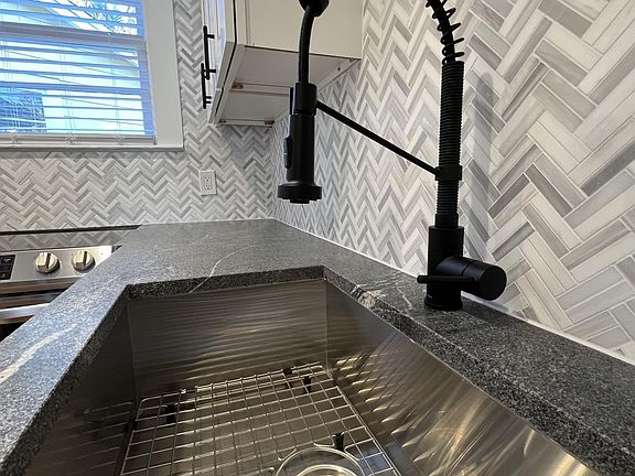 Large stainless steel sink, with bottom drying rack & telescoping faucet.