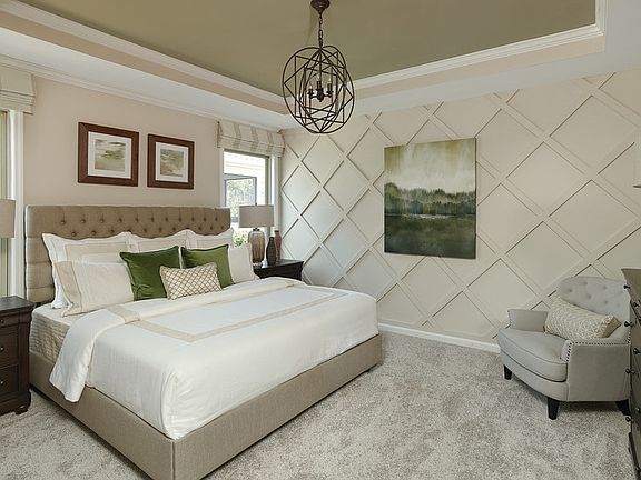 Spacious owner s suite with tray ceiling with contrasting paint color and detailed molding on the ac