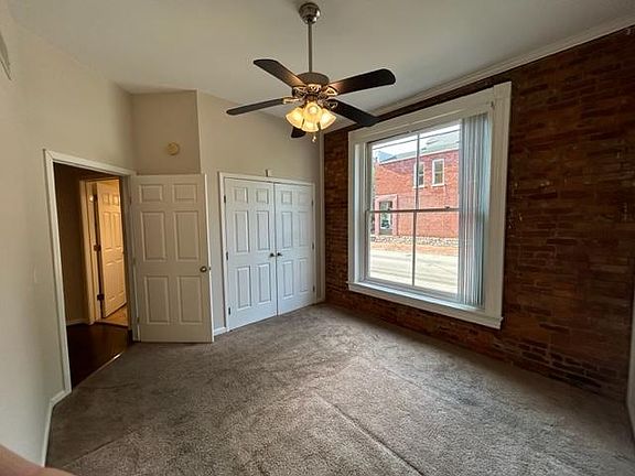 Bedroom #2, with large double closet and exposed brick wall.