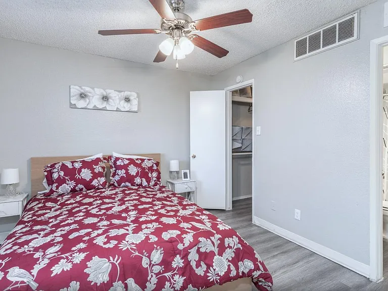Modern bedroom with wood-style floors and ceiling fan