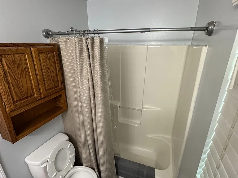 Full bathroom with a tub/shower combo, shower curtain, and wall cabinet for added storage.