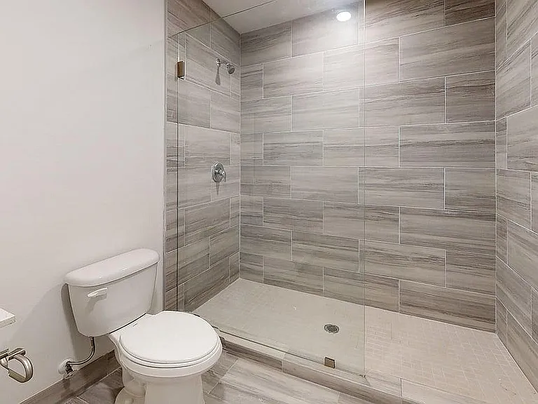 Modern bathroom with a spacious glass-enclosed shower and elegant tile design, offering a sleek and refreshing retreat.