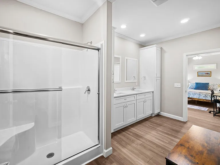 Spacious bathroom with a tub/shower combo, double-sink vanity, and ample cabinet storage for daily essentials.