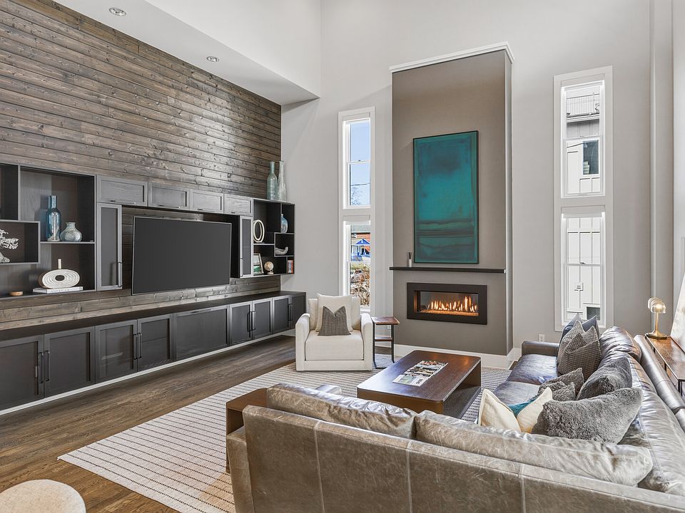 Bright, modern living room with HUGE ceilings. Abundant natural light, plush seating for everyone, a cozy gas fireplace, and a Smart TV_perfect for relaxing.