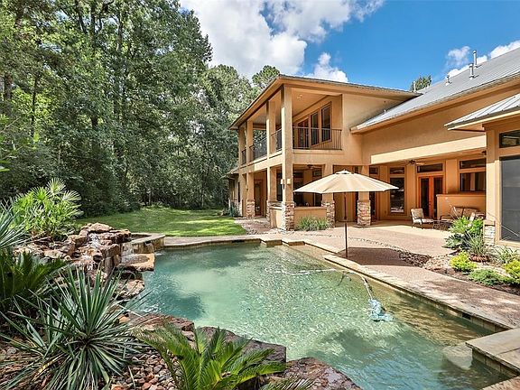Rear View of home with pool and spa! Large covered outdoor patio with outdoor kitchen and access to a pool bath!
