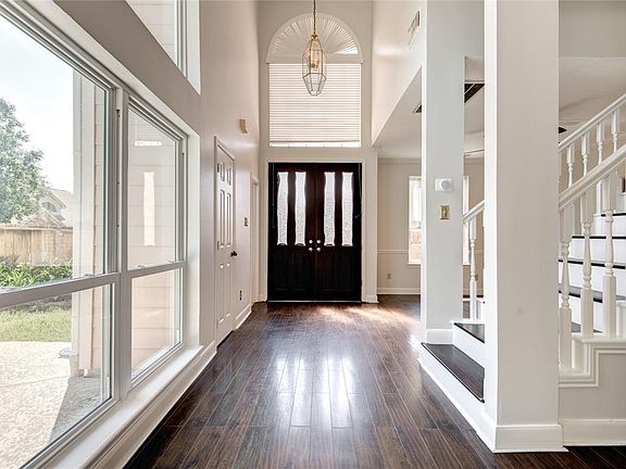 Double doors open into bright two story foyer with view of the POOL.