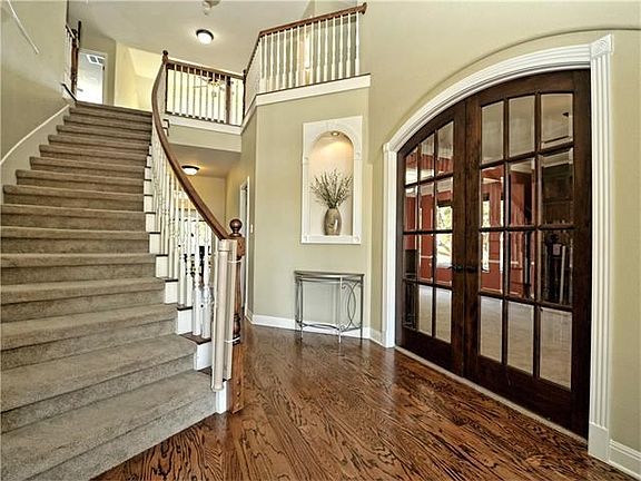 Gorgeous and substantial wood french doors with beveled glass lead to the office/den.