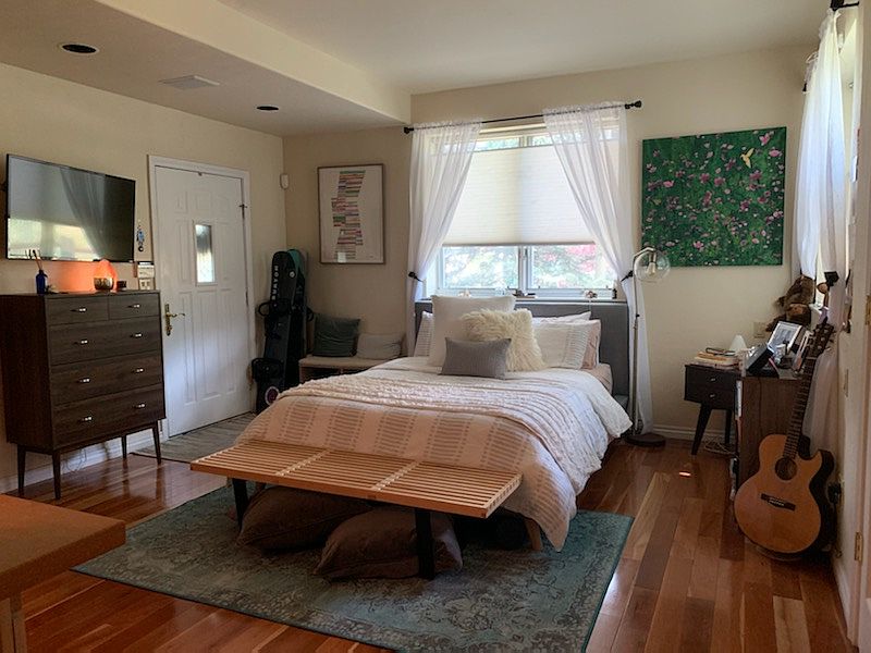 Studio main room with potential furnishings (if desired), Wall Mount 42" TV, Entry door on left, 2 large windows (one over the bed, 1 above guitar, and red cherry hardwood floors