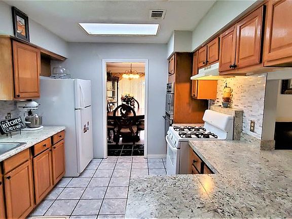 Note the full gas range AND the built-in Micro & extra electric oven. A Baker's dream. Plenty of cabinet and counter space. Note the updated tile floor.