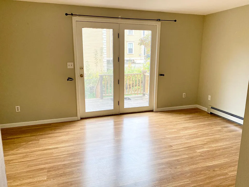 Empty living room, leading to the deck. The deck has been updated since since the picture.