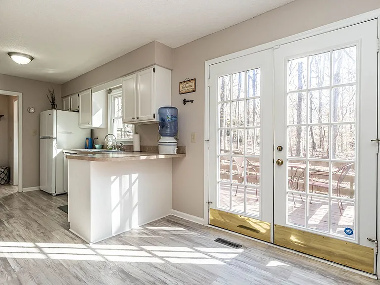 Into the kitchen from the dining room brings you bright airy fully equipped kitchen and you may refill your filtered water at the Durham Food Coop, The french doors encourage outdoor refresh!
