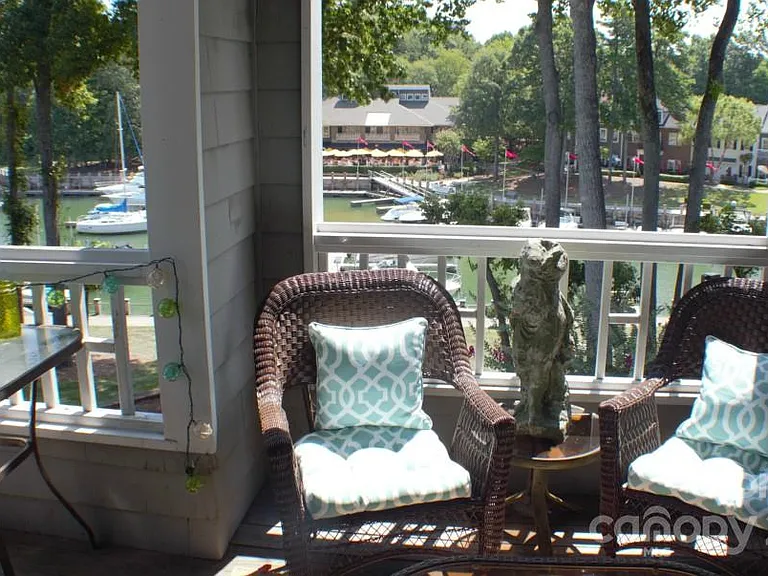 Large deck with table and two chairs, additional two wicker chairs plus loveseat overlooking Lake Norman