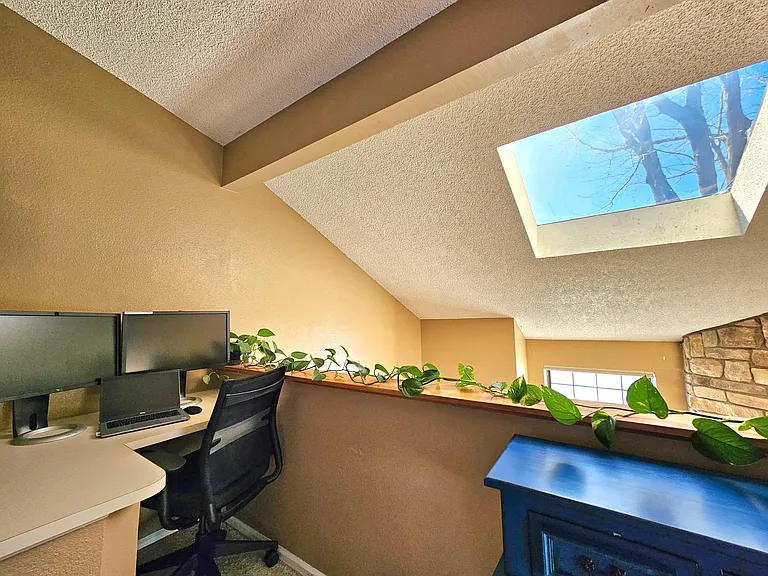 A built-in desk with views of the oak tree from the double high windows and the skylight that also provide a bright workspace.