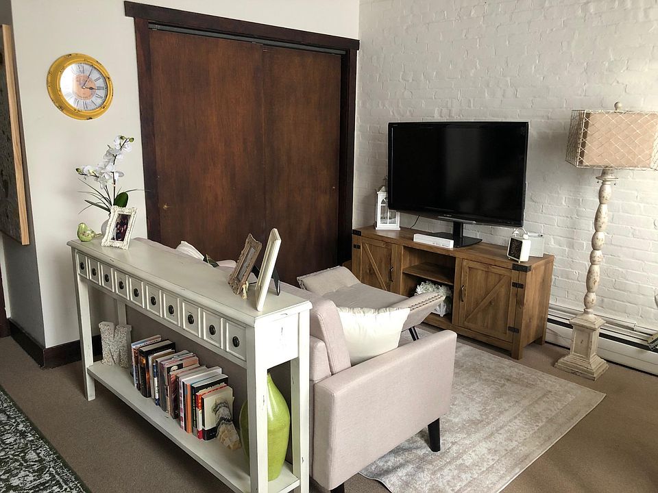 Entry table and living area featuring 1 of 2 closets. TV table, TV, ottoman available for sale if desired