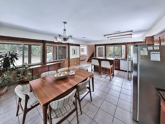 Granite & stainless eat-in kitchen with handmade cherry cabinets, door to fenced in area that backs to woods and doors to screened in front porch.