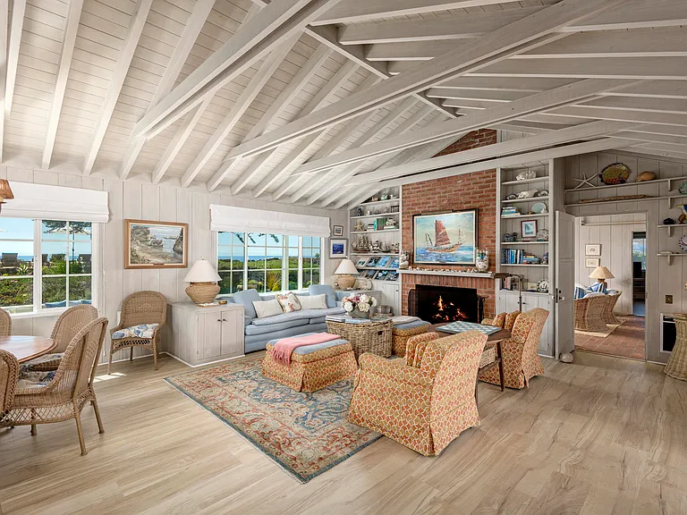 Open dining and living room with wood burning fireplace and ocean views.