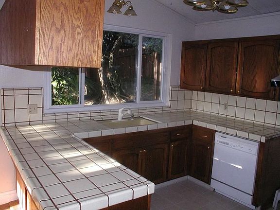 Kitchen has view of the lush green yard.