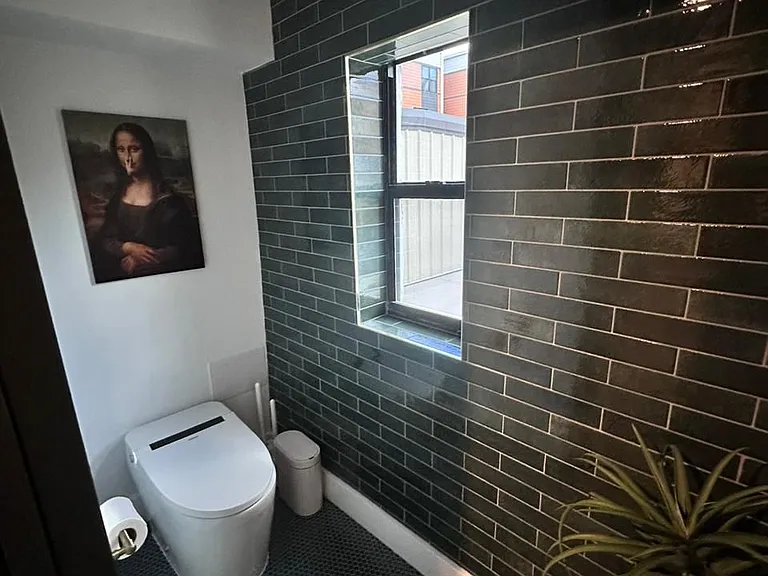 Luxury bathroom with decorative artwork and a sleek modern smart toilet.