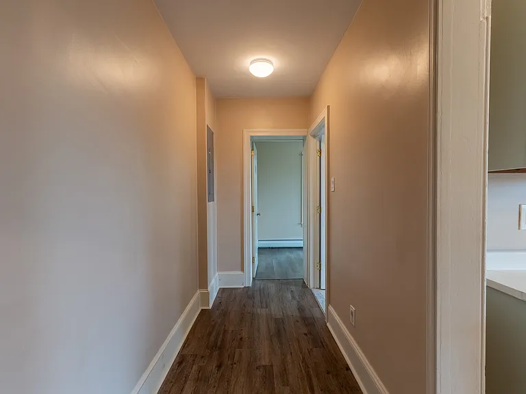 Hallway connecting outside of kitchen to bathroom and office/extra bedroom.