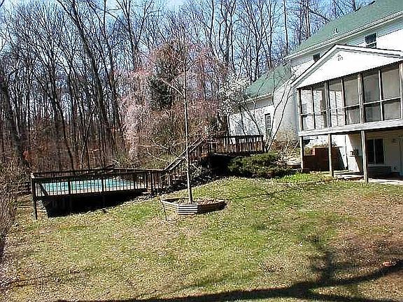 Rear elevation with screened porch and above-ground pool