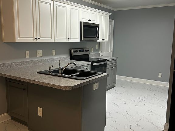 Beautiful kitchen with bar seating; includes stove, built in microwave, dishwasher & refrigerator