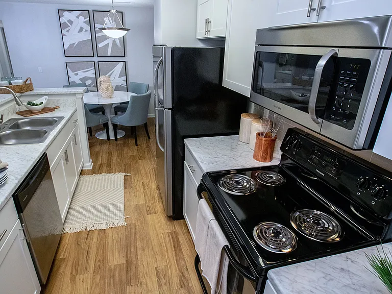 This open, galley-style kitchen provides abundant counter space for cooking and a chic breakfast bar to create a perfect blend of style and functionality.