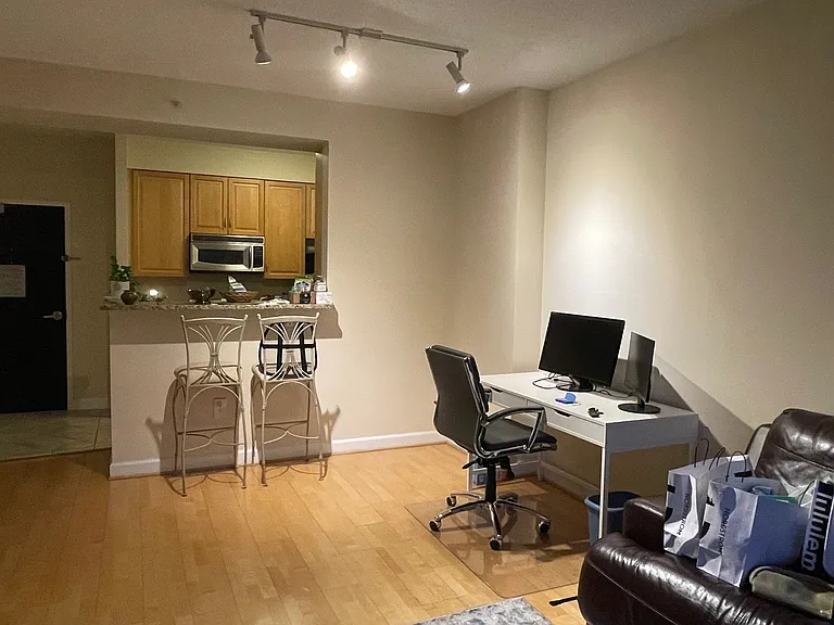 Looking from the living room towards the kitchen and the breakfast counter, and the unit entrance