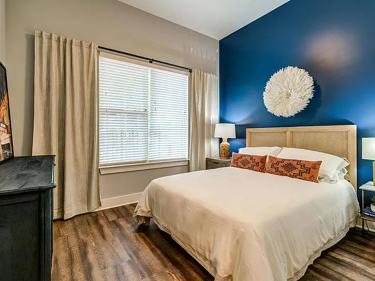 Stylish Bedroom with Textured Decor, Tall Windows, and Designer Touches