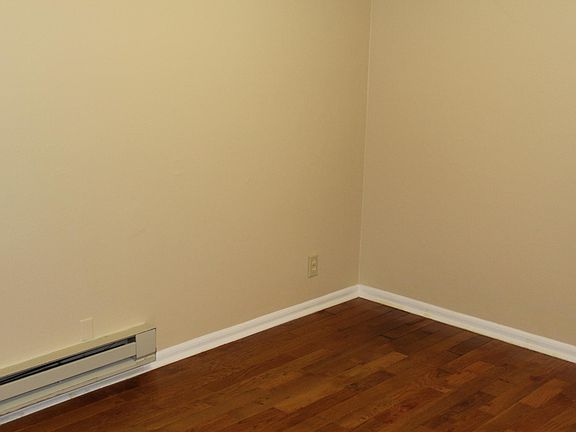 ... standing in the middle of the eastside bedroom and viewing the baseboard heater and the floor
