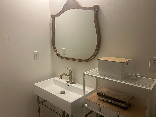 Guest bathroom with shelving for extra storage space.