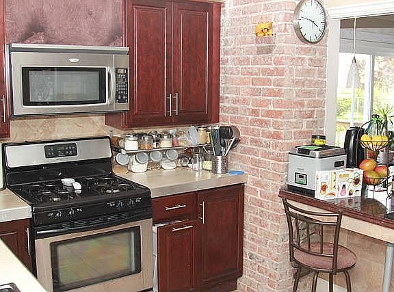 Kitchen - Exposed brick + stainless steel appliances