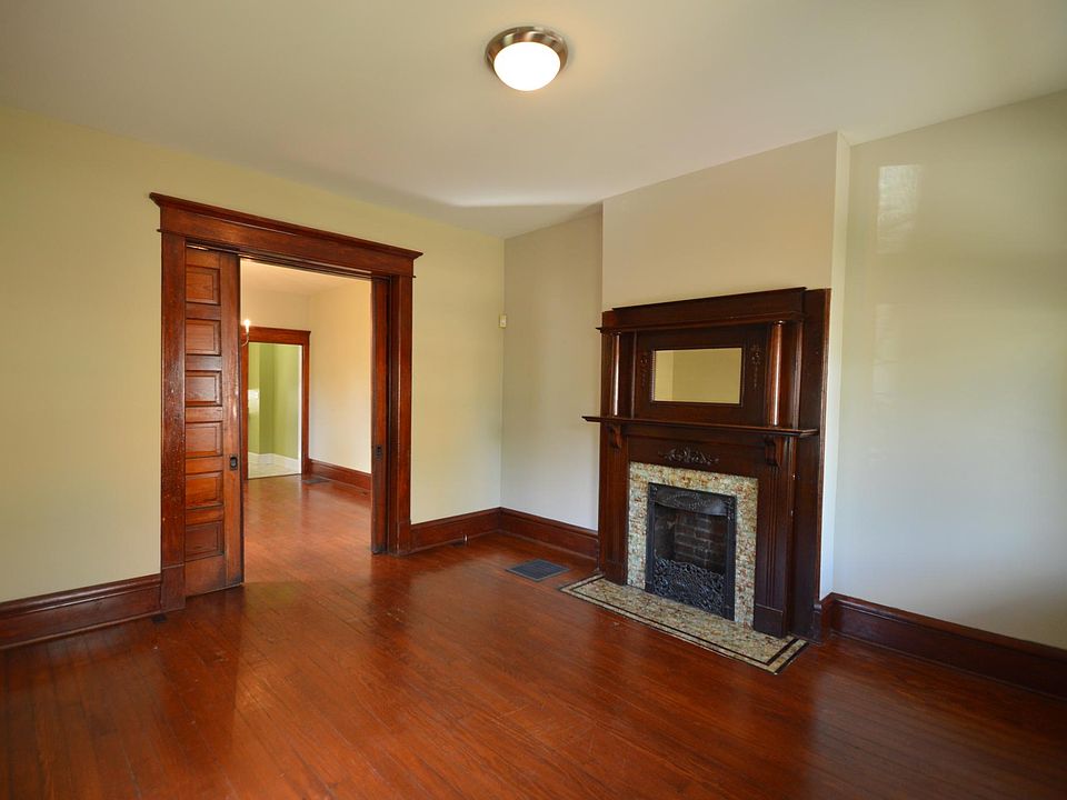 Living room with working pocket doors and decorative original fireplace.