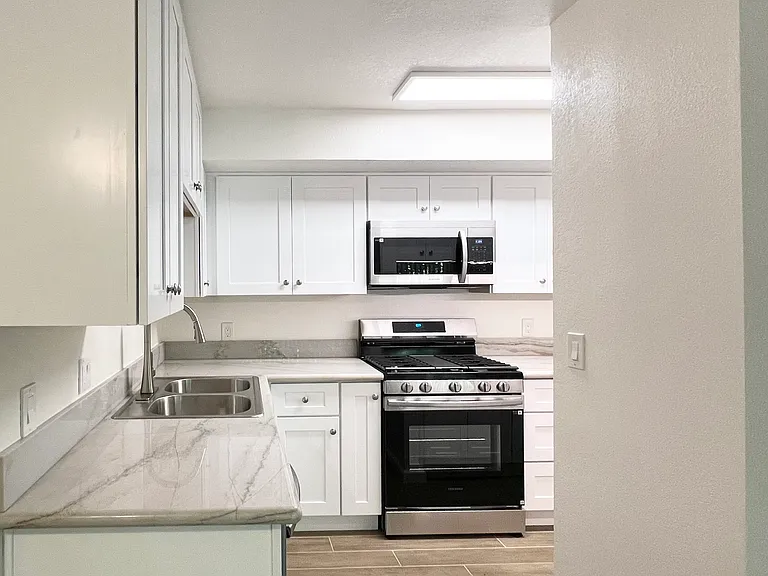 Kitchen Sink Area w/tile flooring. All new and modern stainless steel front appliances
