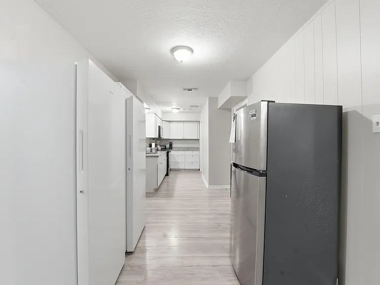 Galley-style kitchen with ample cabinet storage, generous counter space, and a full appliance package for easy meal prep.