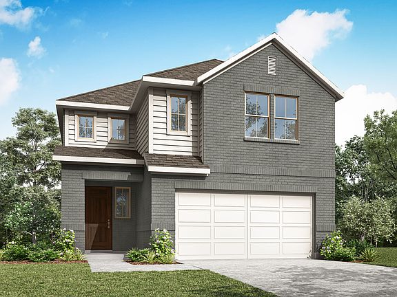 A two-story gray house with a garage stands in a grassy area surrounded by trees against a blue sky