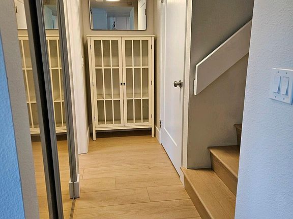 Hallway off kitchen and living room. Up the stairs to the right takes to master suite + patio. Door behind that is the guest bath/bath 2. Hallway closet on the left, and past that the #2 bedroom door.