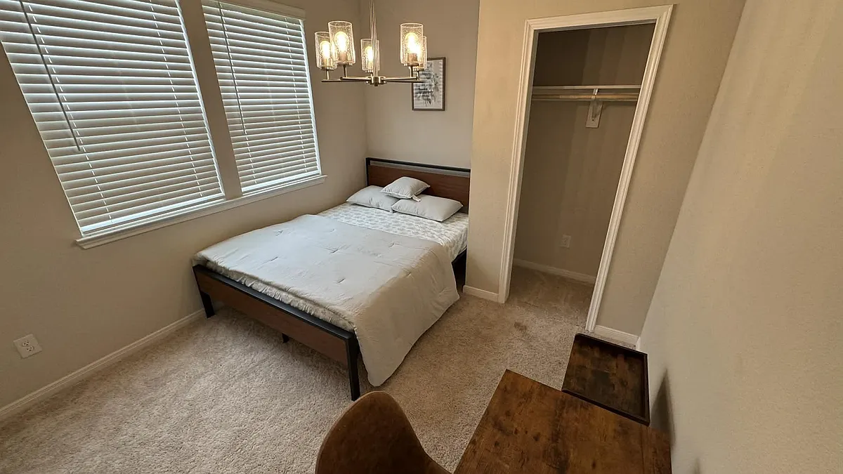 Photo 1 of 10 - Basil Beebalm Trl - Magnolia, TX Furnished bedroom with large windows, neutral carpet, and an open closet for convenient everyday storage. - Basil Beebalm Trl