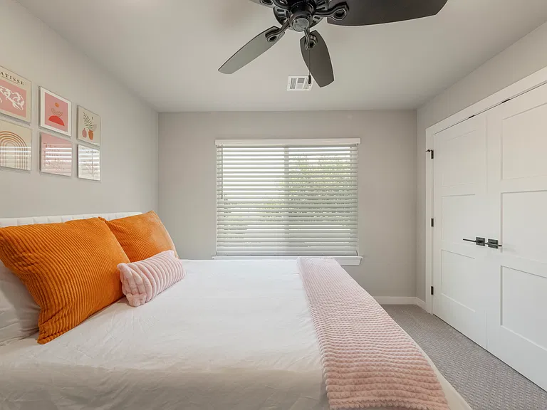 Second bedroom includes queen-sized bed, furnishings, large closet with shelving and TV.