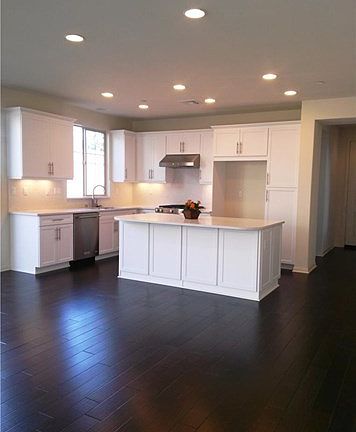 Bright kitchen with rich wood flooring, stainless appliances and open floor plan