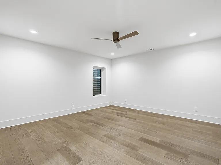 Spacious bedroom with clean lines and ceiling fan