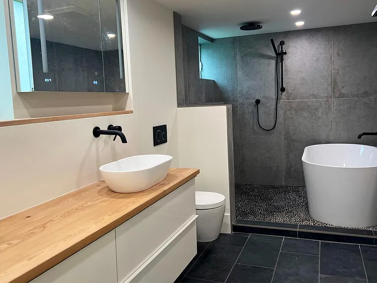 Jack & Jill spa bathroom with high-tech mirror cabinet, open rain shower wet area including a large freestanding soaking tub